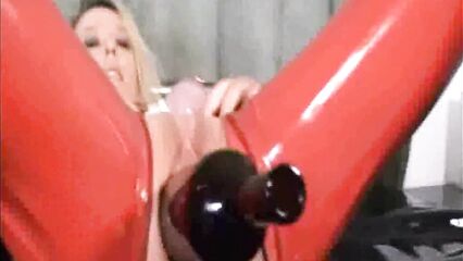 Блонда в красном латексе трахает себя бутылкой